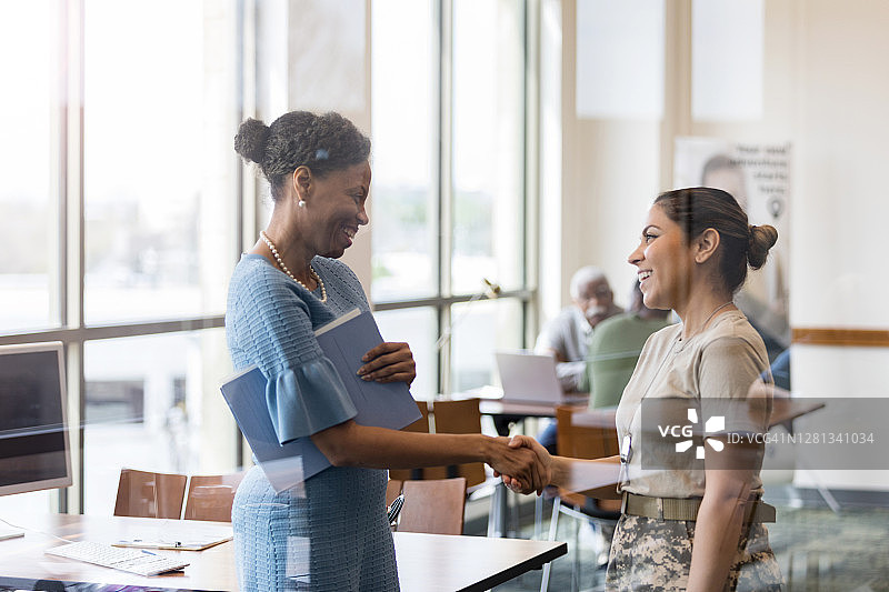 自信的女军人与银行职员会面图片素材