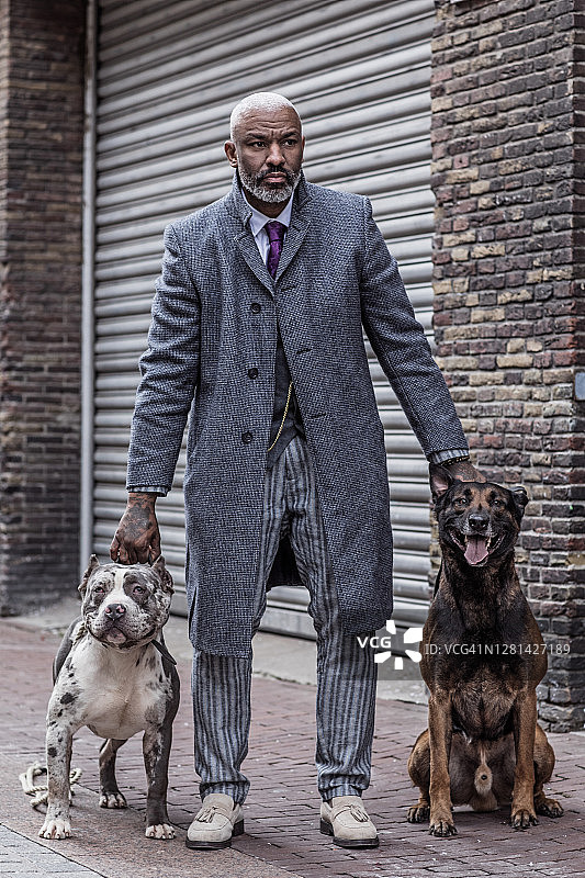 老城区里带着狗的黑人复古黑帮男子肖像图片素材