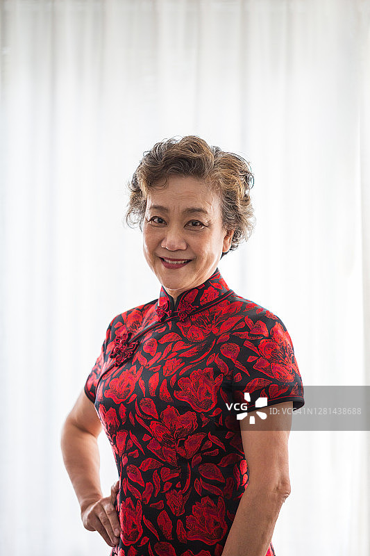 身穿旗袍的年长女性肖像：老年妇女的退休生活图片素材