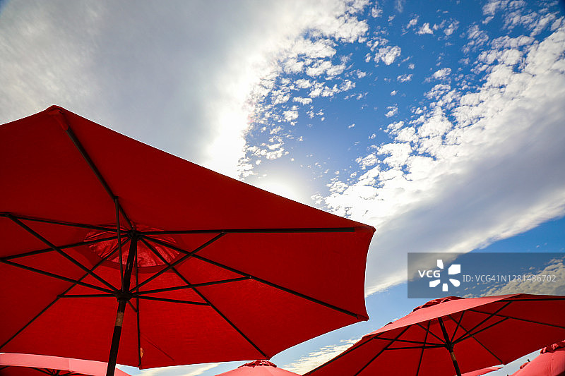 墨西哥纳亚里特蔚蓝天空和云朵下的红色雨伞图片素材