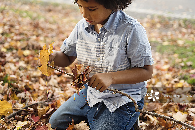 多种族小男孩在城市公园玩耍秋叶图片素材