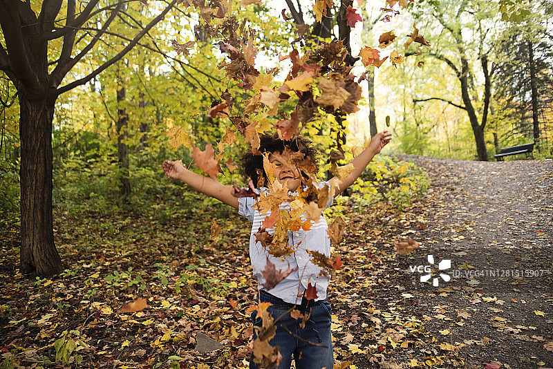 多种族小男孩在城市公园玩耍秋叶图片素材