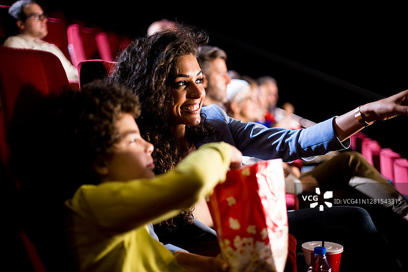 快乐的女人和儿子在电影院图片素材