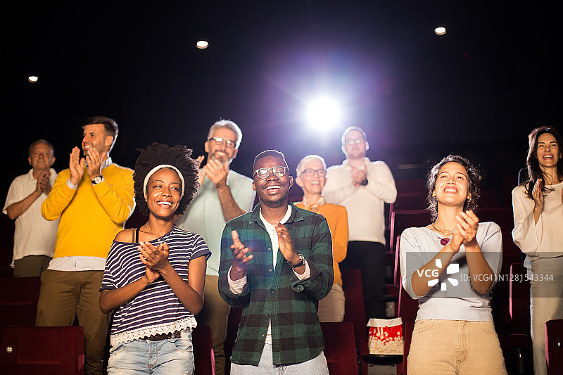 人们在电影院观看电影后鼓掌欢呼图片素材