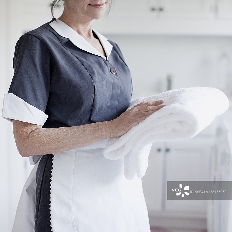 酒店女服务员拿着叠好的毛巾（中段）图片素材