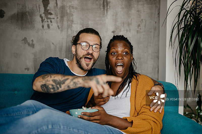 情侣在家中沙发上看电视放松图片素材