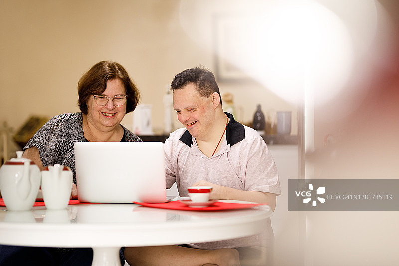 快乐的男人和有特殊需求的人使用笔记本电脑图片素材