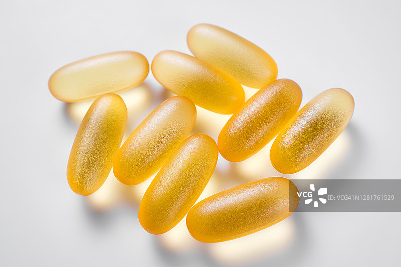 白色背景或木勺上的Omega-3鱼油胶囊，健康生活方式，疾病的预防和治疗，膳食补充剂和维生素，生物活性添加剂图片素材