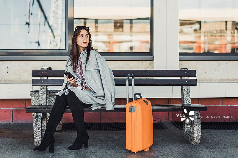 坐在长椅上等火车的女人图片素材