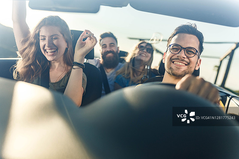 朋友们在敞篷车之旅中快乐舞蹈图片素材