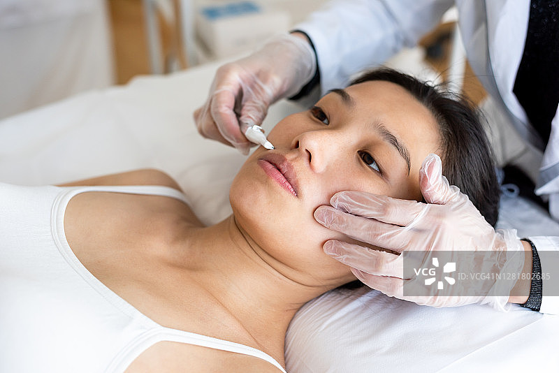 激光脱毛护理：年轻女子在美容院接受治疗图片素材