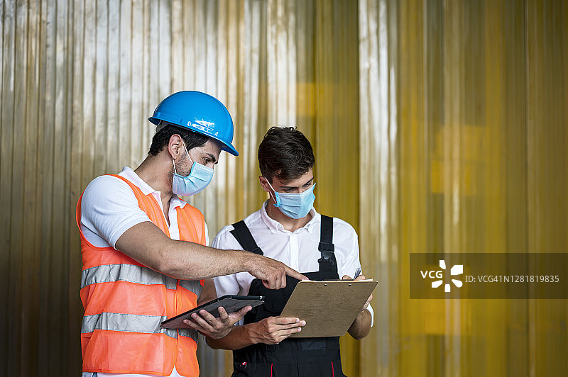 仓库工人在冷冻食品仓库一起讨论库存报告图片素材