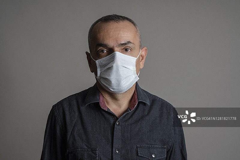 戴着外科口罩的中年男人特写肖像图片素材