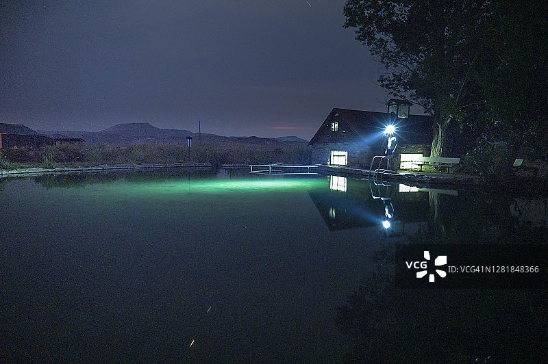 夜晚站在游泳池旁边并戴着头灯的人图片素材