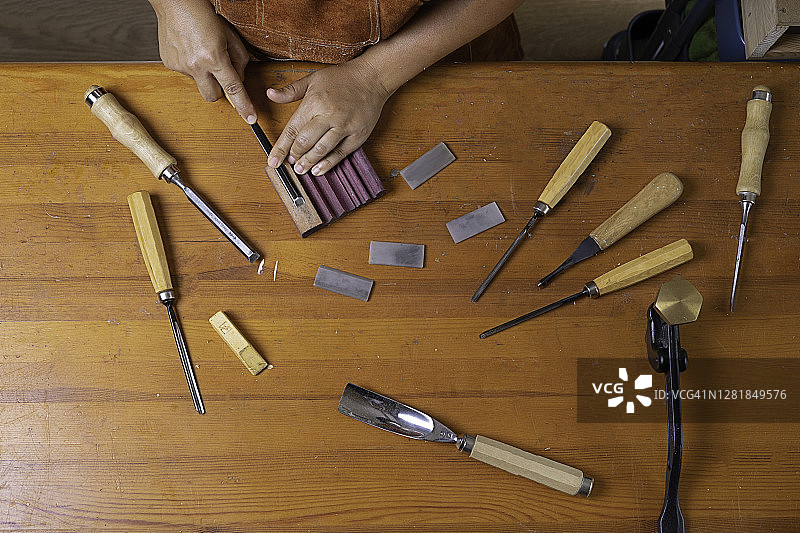 女工匠用石头磨利工具图片素材