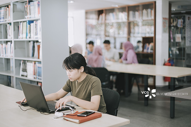在图书馆学习的亚洲女大学生图片素材