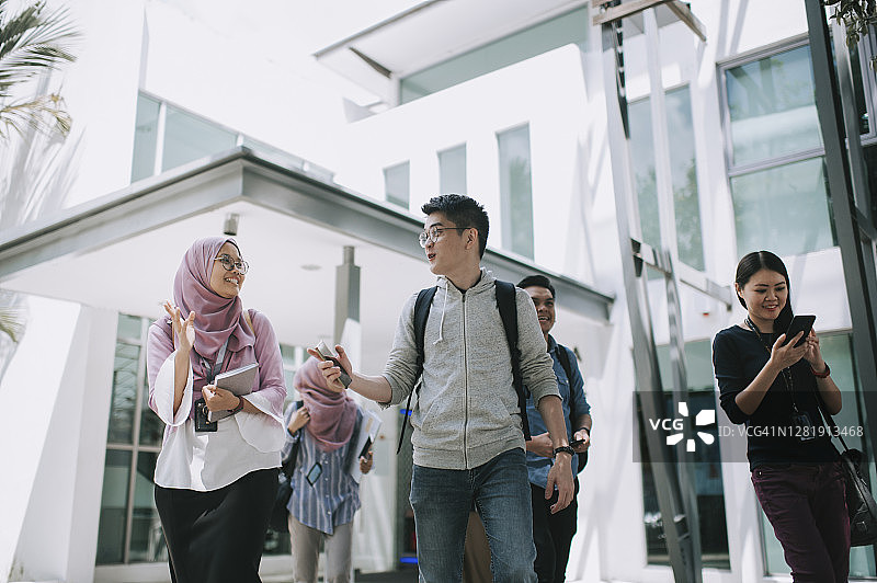 亚洲大学生走出教学楼交谈图片素材