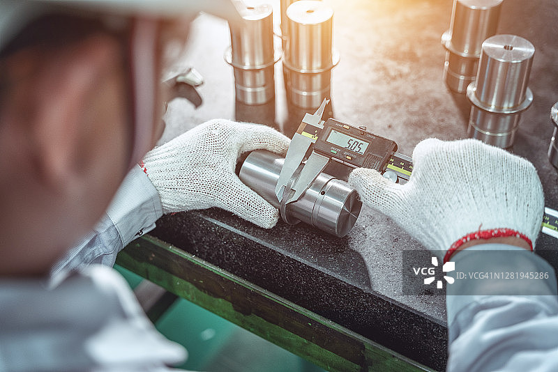 工人使用游标卡尺检验产品图片素材