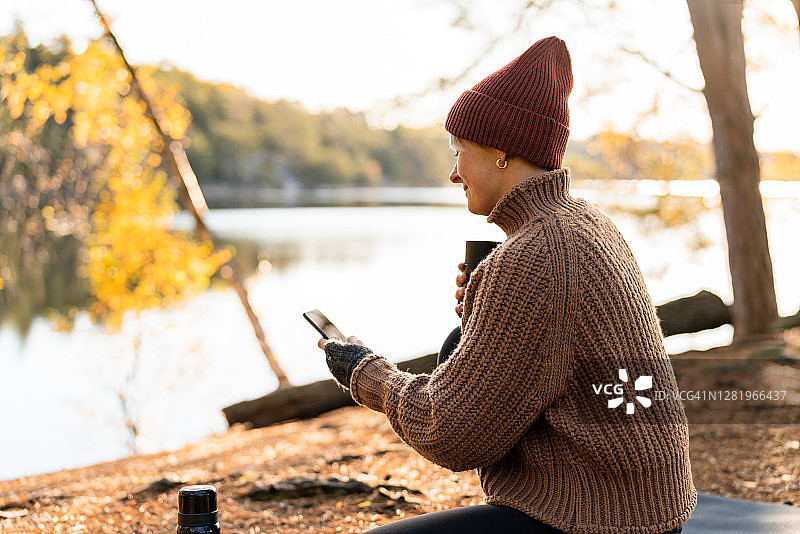 在秋季森林中使用智能手机图片素材