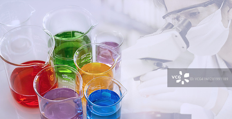 实验室概念：烧杯中的化学试剂俯视图，科学家在实验室用显微镜测试的模糊背景图片素材