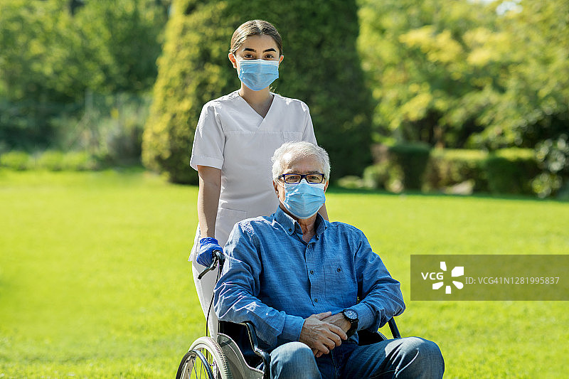 护士照顾坐轮椅的老年男子图片素材