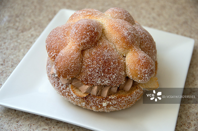 石质厨房台面白色盘子上的巧克力奶油亡灵面包图片素材