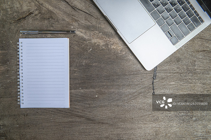 木桌上的笔记本、笔和电脑图片素材