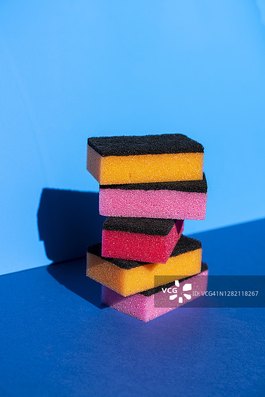 蓝色背景上的彩色清洁海绵堆叠图片素材