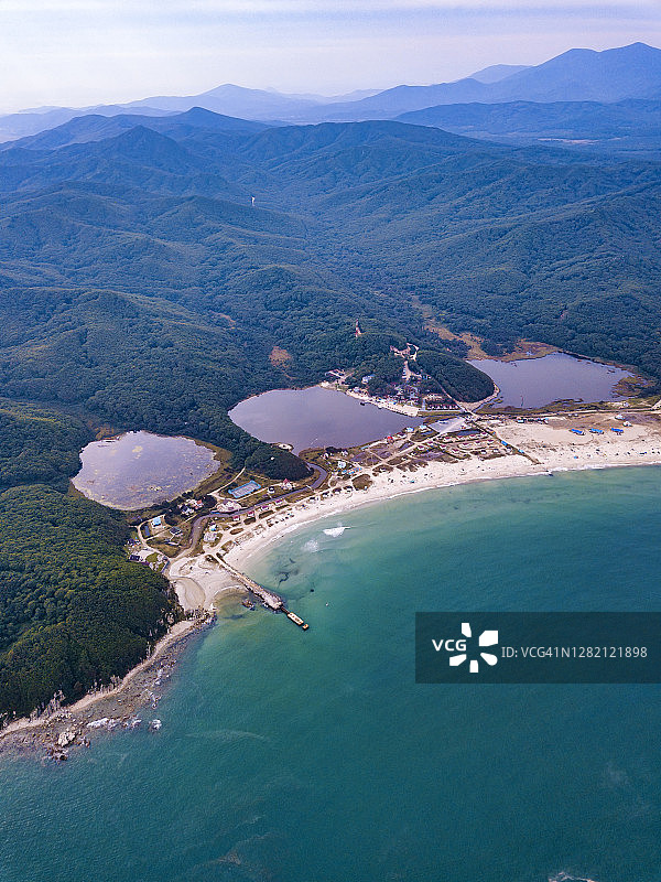 俄罗斯滨海边疆区纳霍德卡：三湖海滩和森林山丘的航拍景色图片素材