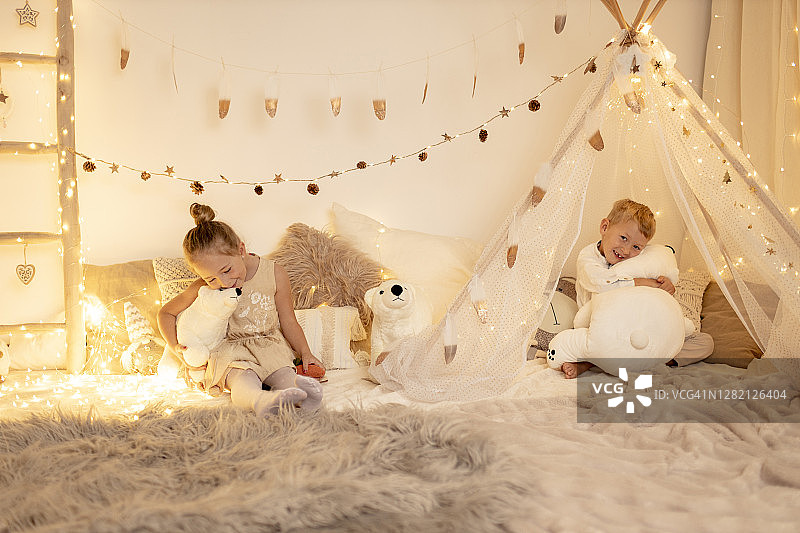 兄妹在房间里玩玩具熊图片素材