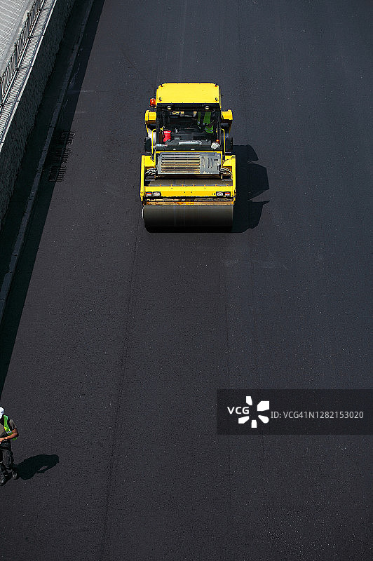 沥青摊铺机正在铺设新路面图片素材