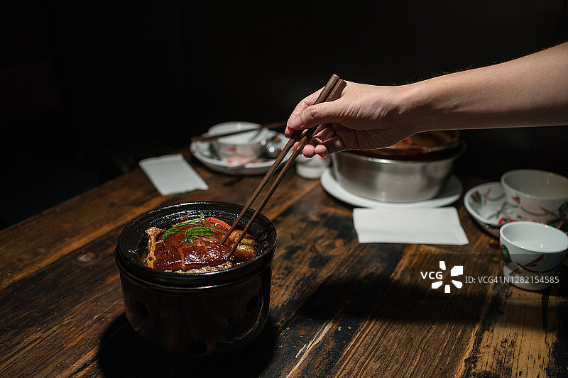 在餐厅吃东坡肉的亚洲男人图片素材