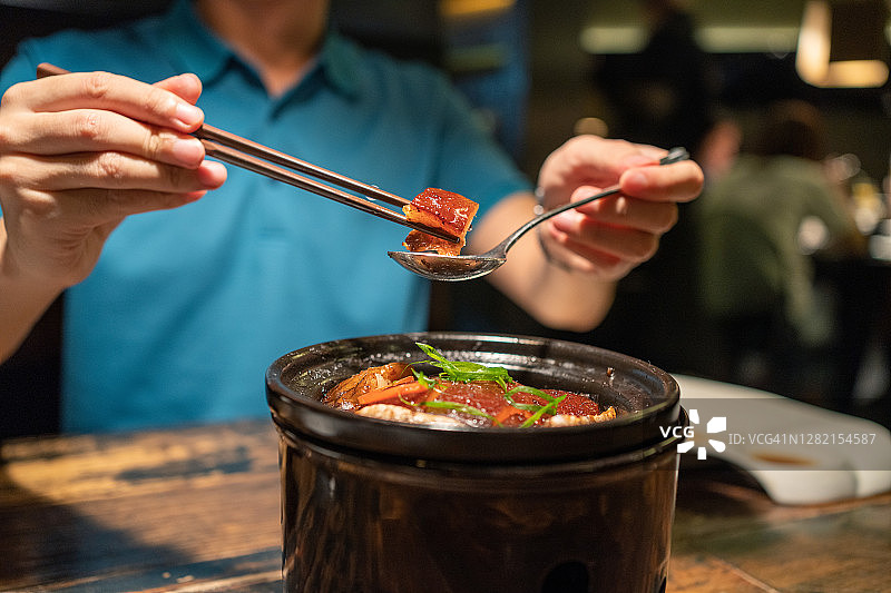 在餐厅吃东坡肉的亚洲男人图片素材