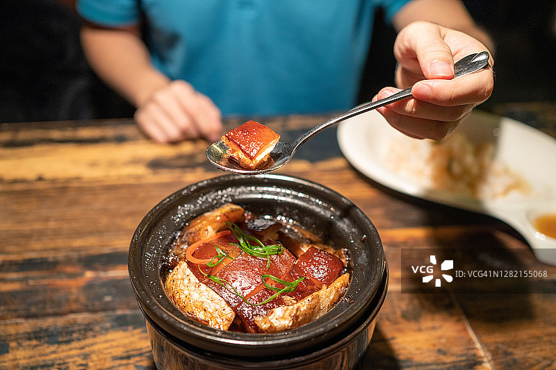 在餐厅吃东坡肉的亚洲男人图片素材