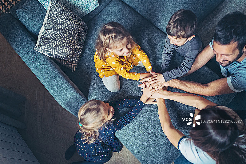 在沙发上玩耍的与三个孩子的一家人图片素材