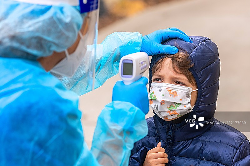 女护士为即将返校的男孩测量体温图片素材