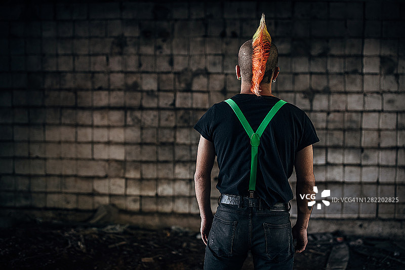 在废弃仓库中发型色彩鲜艳的朋克的背影图片素材