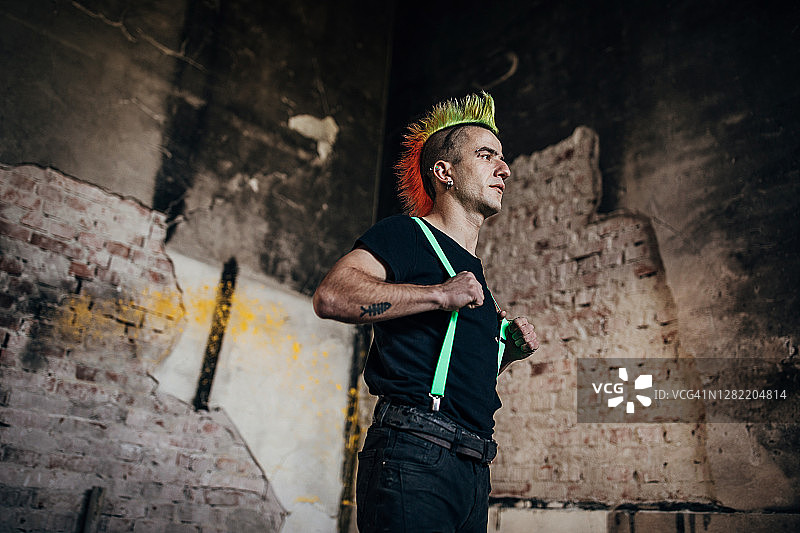 发型色彩鲜艳的朋克站在废弃的仓库里图片素材