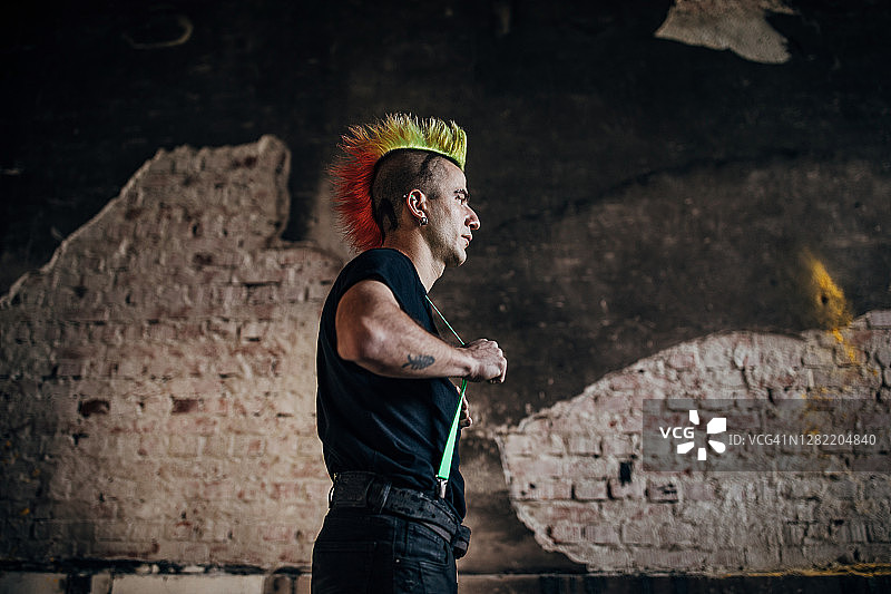 一个年轻的朋克站在废弃的仓库里图片素材