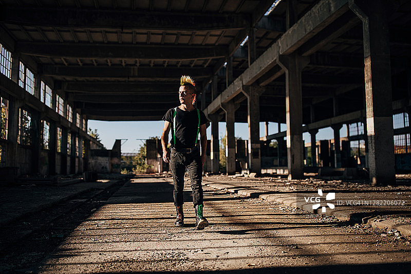 发型色彩鲜艳的朋克在废弃仓库里行走图片素材