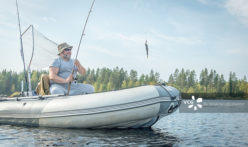 男子在河上泛舟钓鱼图片素材