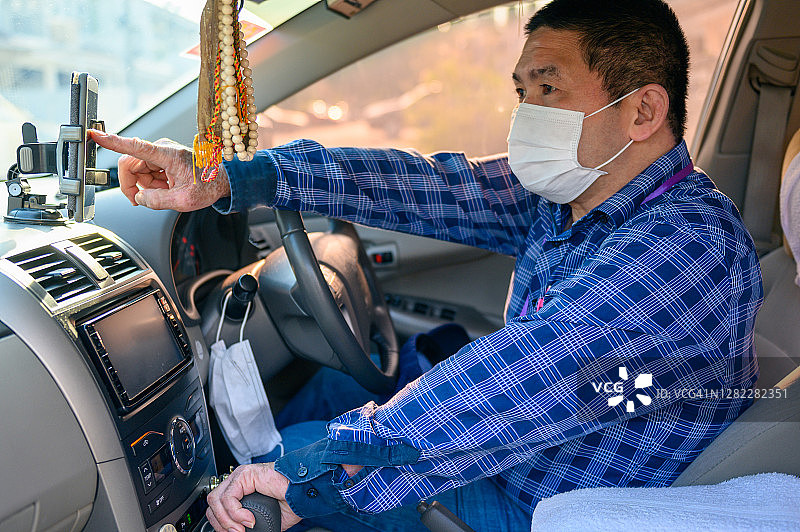 戴口罩的亚洲网约车男司机，准备接单。Uber司机图片素材