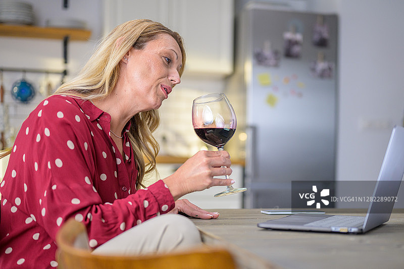 使用笔记本电脑进行视频会议的成年金发女性图片素材