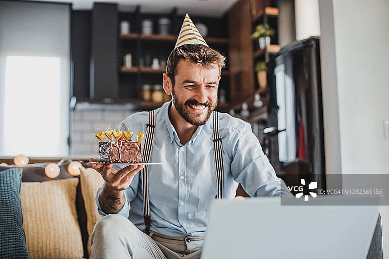 年轻男人在家中通过视频通话庆祝生日图片素材
