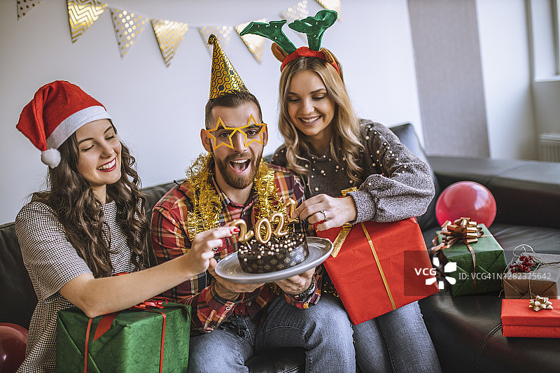 朋友们在新年派对上交换礼物，吃巧克力蛋糕的照片图片素材