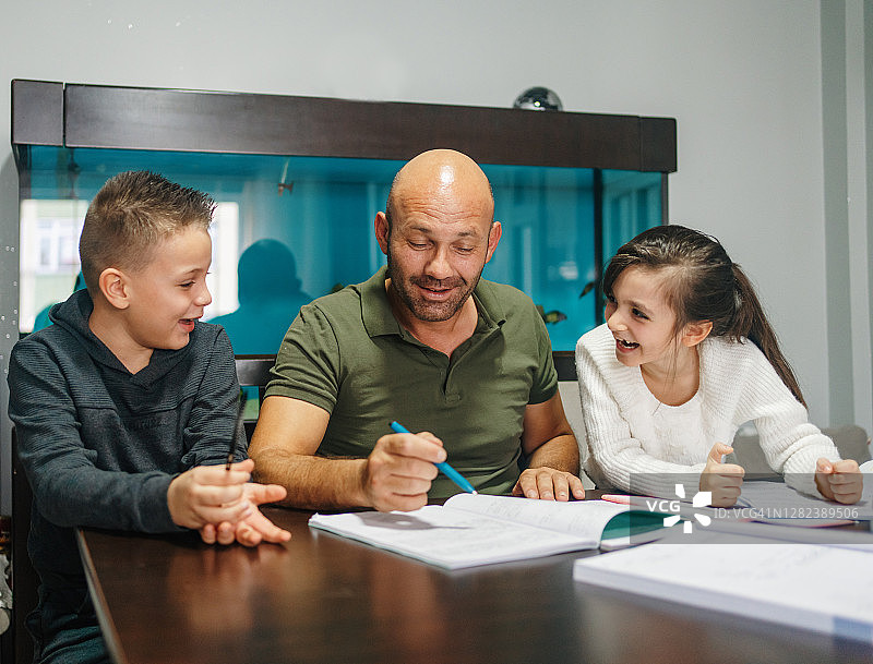 父亲辅导孩子们做作业图片素材