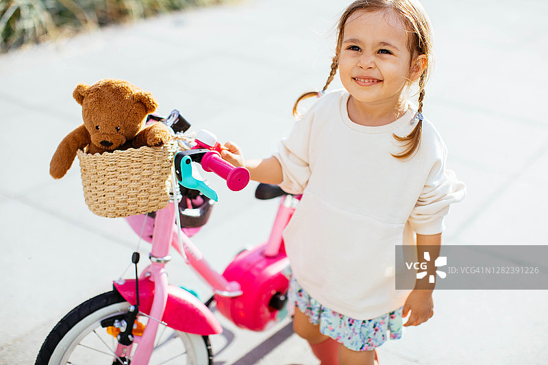 快乐的女孩在公园里骑自行车图片素材