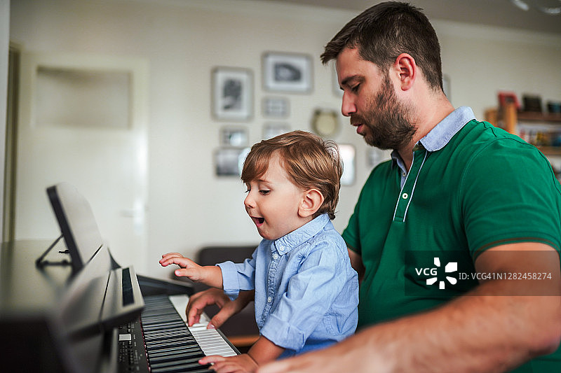 对钢琴充满好奇的男婴图片素材