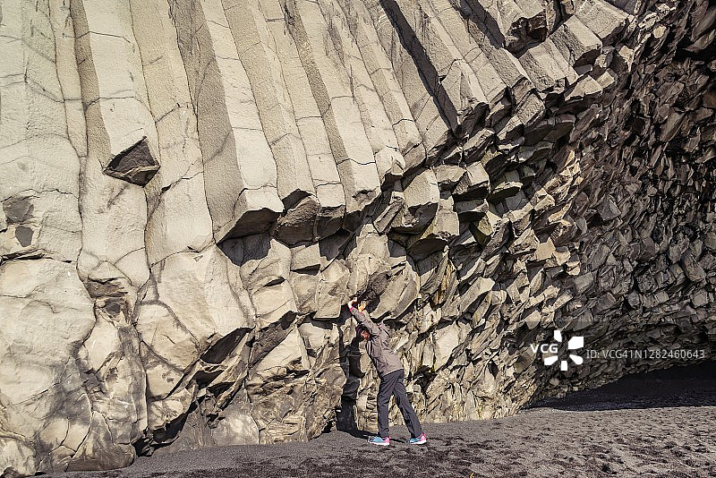 在冰岛Halsanefshellir玄武岩柱墙壁旁边的女孩图片素材
