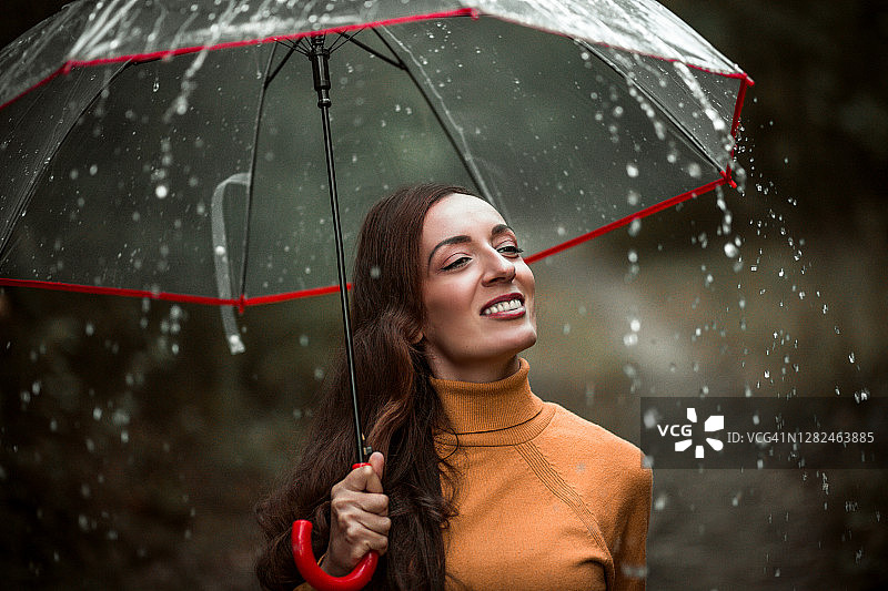 美丽的年轻女子享受着雨天图片素材